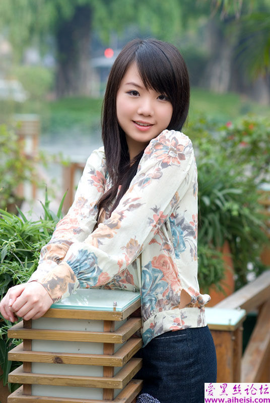 时尚的花衬衣女生在大街上的随拍照片