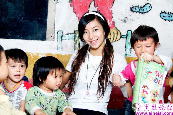 美丽温柔的幼儿园老师展示出自己与小朋友的照片